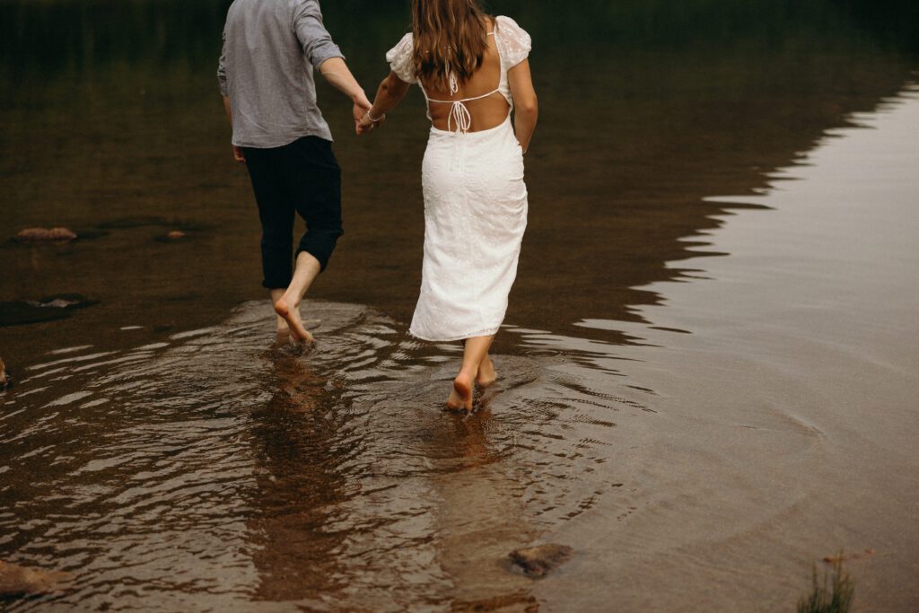 man and woman walking in the water holding hands