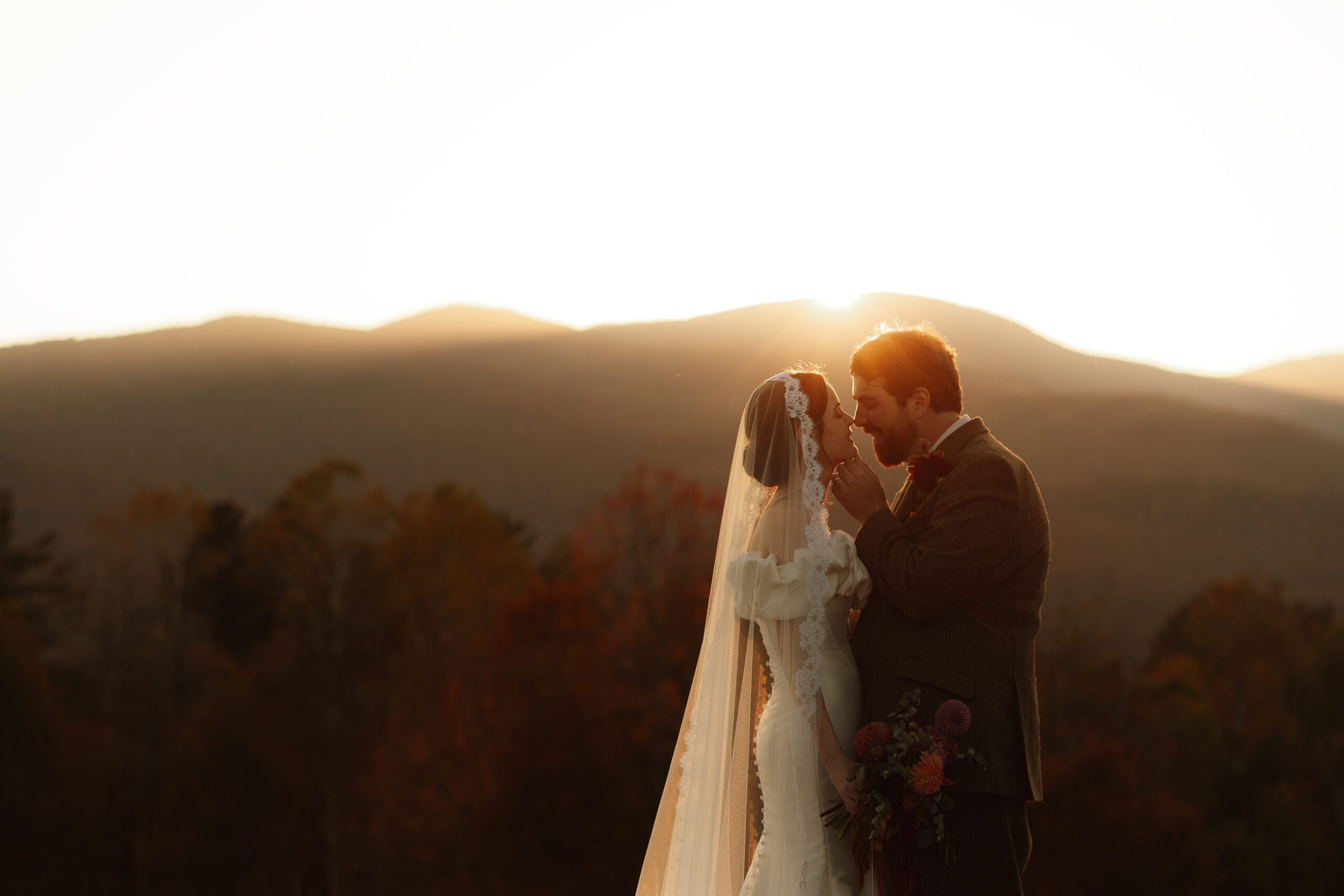 Bride and groom sharing a sunset moment at a mountain wedding venue in Vermont with fall foliage and scenic views