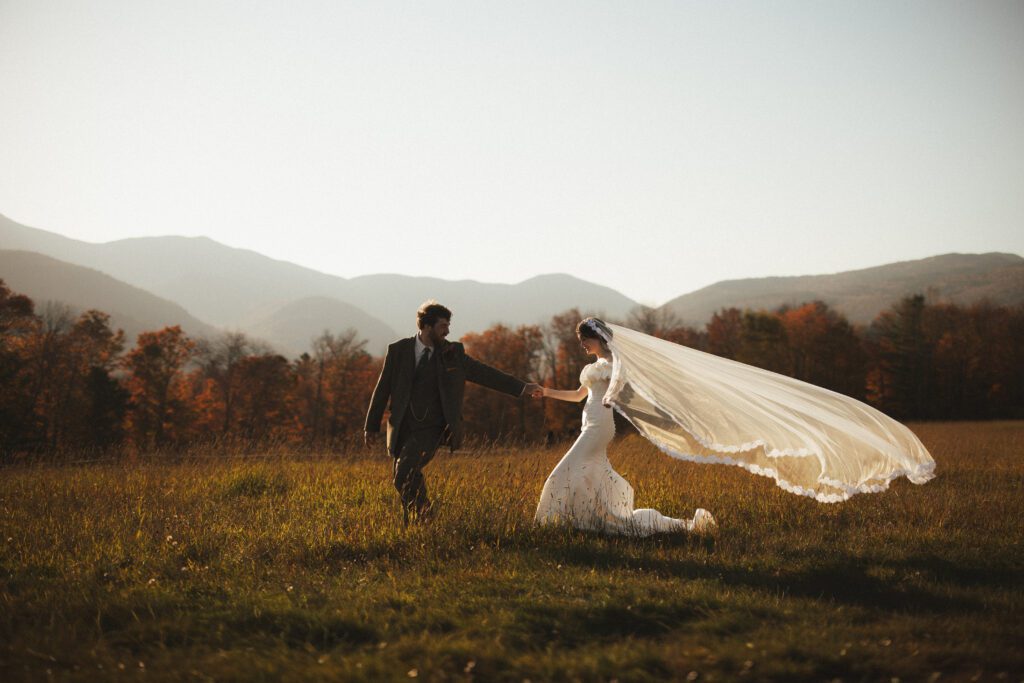 Bride and groom during a fall wedding at Trapp Family Lodge in Stowe, Vermont with vibrant autumn foliage and mountain views